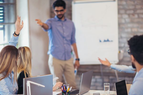 Businessman At Whiteboard Giving Presentation In Boardroom